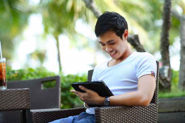 man sitting and holding tab